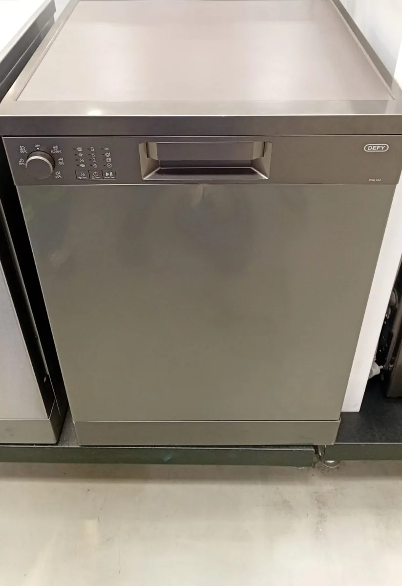 Dishwasher prepared for appliance plumbing connections in a showroom-style setting.
