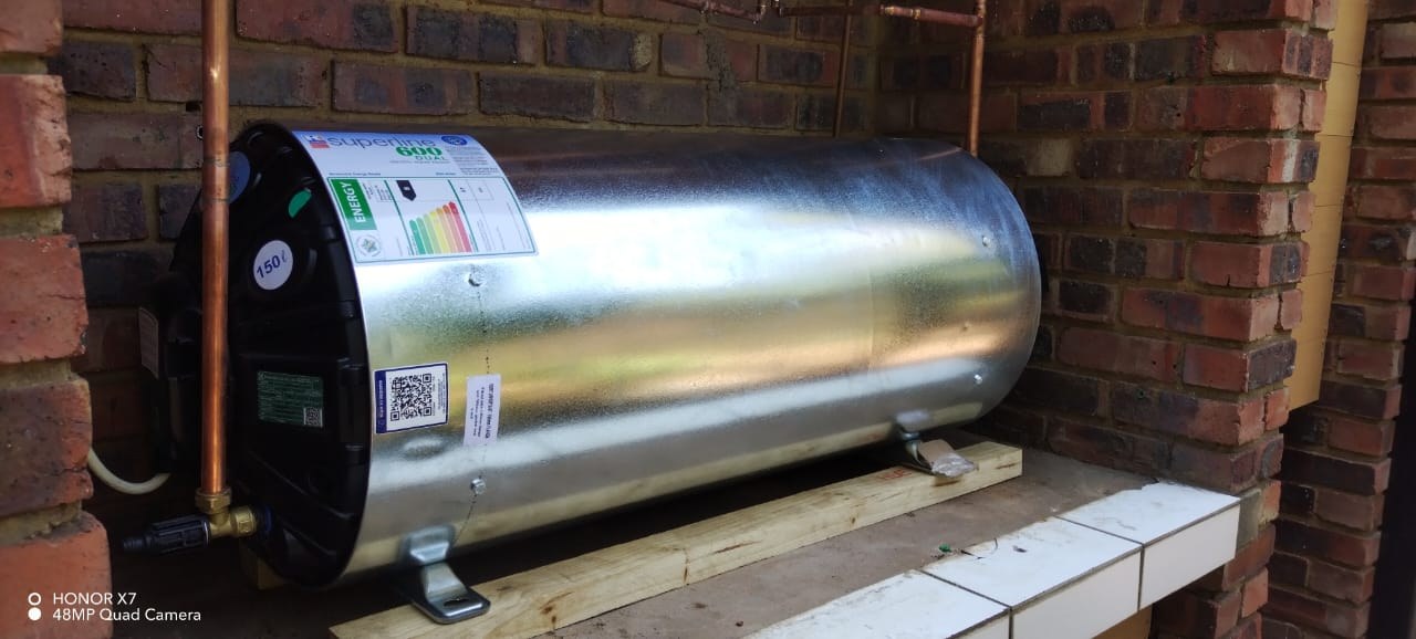 Geyser replacement image showing a newly installed horizontal hot-water cylinder mounted in a brick recess by Plumb A Nator.