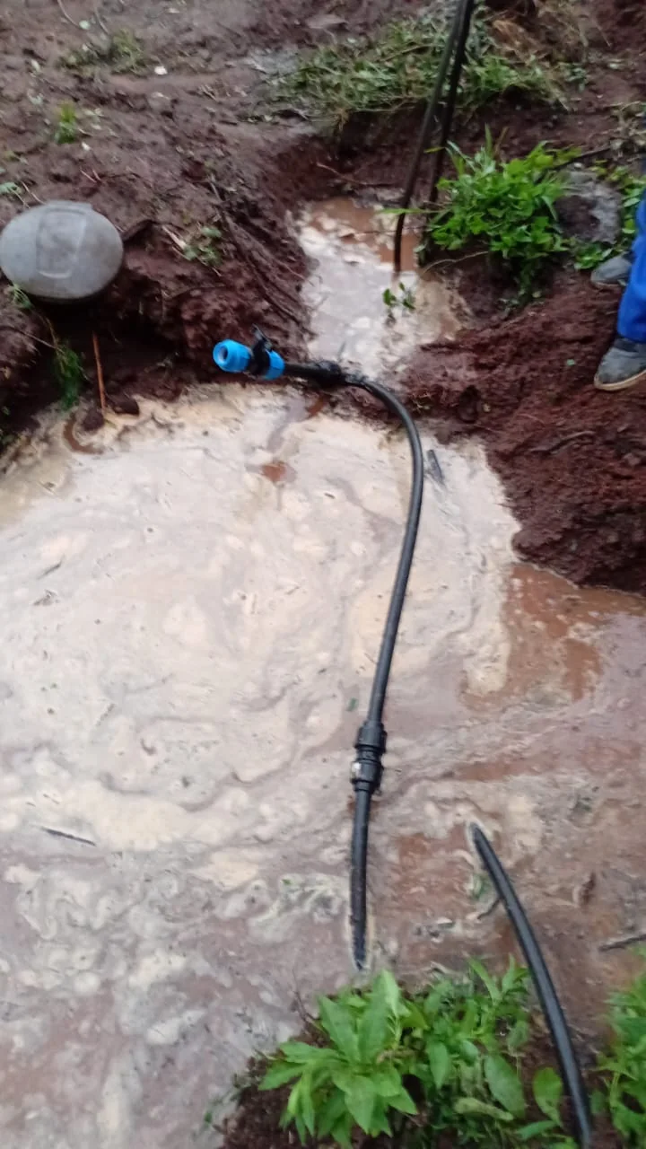Underground water pipe repair in a muddy excavation after leak isolation.
